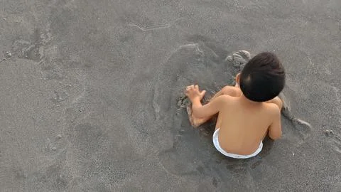 A Child Playing In The Beach Stock Photos