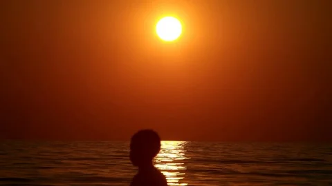 Child playing on the beach at sunset Stock Footage 73580674