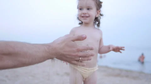 Child Playing on the Beach while Father Show her Sand and Girl Smiling Stock Footage 65511845