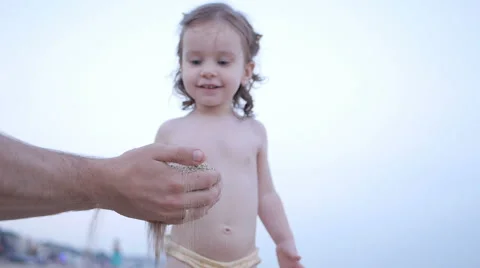 Child Playing on the Beach while Father Show how Sand Pours from Hands Stock Footage 65525487