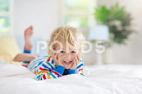 Child playing in bed. Kids room. Baby boy at home. Stock Photos