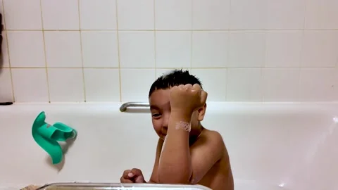 Child playing with bubbles during a fun bath Stock Footage 334450186
