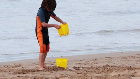 Child Playing with Bucket on Beach Vídeos de archivo 301033396
