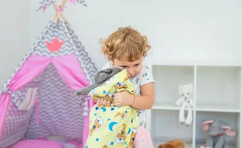 The child is playing with the cat. Selective focus. Foto stock