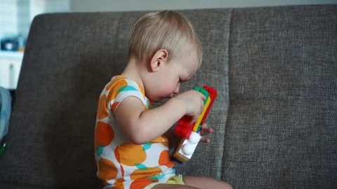 Child playing with colored blocks on the couch Stock Footage 82934563