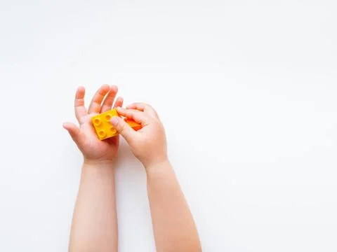 Child is playing with colorful constructor blocks. Kid's hands with bricks to Stock Photos