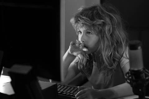 Child playing computer games or studying on pc computer. Kid gamer on night neon 写真素材