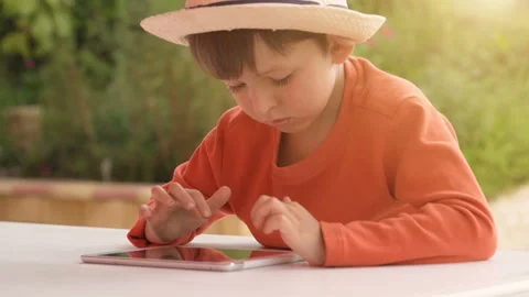 Child playing with digital tablet on summer nature background Stock Footage 95796578