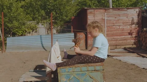 A child playing with a doll in nature, playing with a doll Stock-Footage 336537237