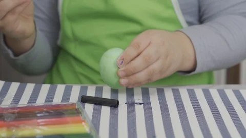 A child playing with an egg and hits it on the table. preparing for Easter Vidéo 127964081