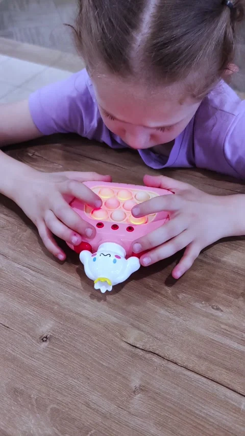 A child is playing with an electronic toy. Close up on electronic pop it fidget. Stock Footage 279636931