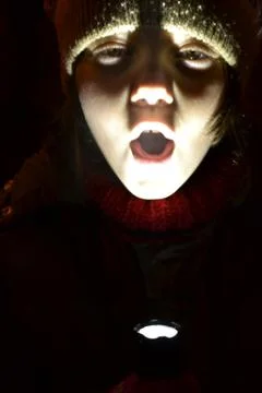 Child Playing With  A Flashlight In Darkness Stock Photos