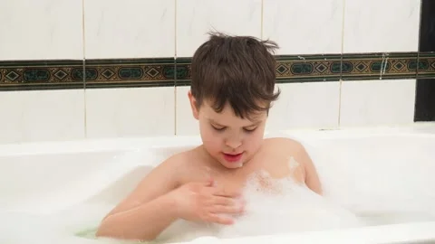 Child playing with foam bubbles while taking a bubble bath 库存影片 150518055