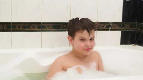 Child playing with foam bubbles while taking a bubble bath Stock Footage 150518132