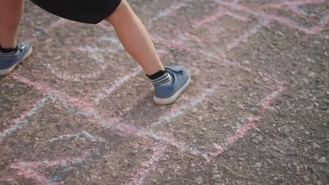 Child is playing game of hopscotch while jumping. happy family kid dream concept Stock Footage 281423591