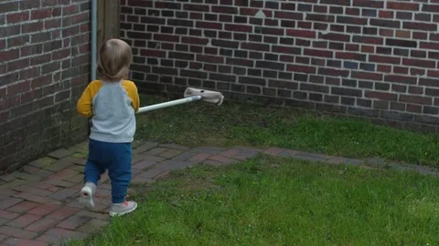 Child playing with garden broom Stock Footage 314346800