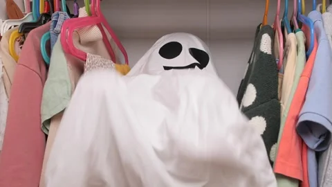 Child playing ghost in closet. Playful ghost sneaking in a child's closet Stock Footage 284567971