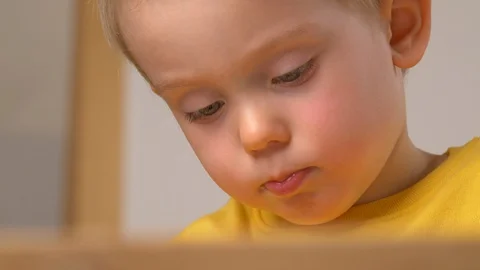 Child is playing indoor, diligently doing something. Stock Footage 128090541