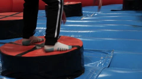 Child playing on inflatable obstacle attraction with rotating arm during event Stock Footage 336468792