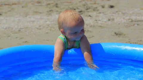 The child is playing in the inflatable pool in the water Video stock 95410553