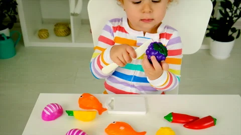 The child is playing in the kitchen preparing to eat. Selective focus. Stock Footage 221128134