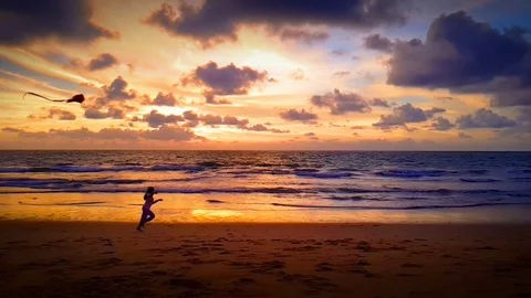 Child playing with kite on the beach at sunset. Stock-Footage 82869842