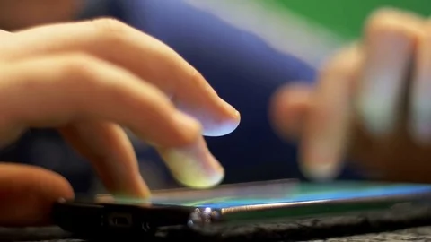 Child Playing with Mobile Phone on the Table Stock Footage 70996438
