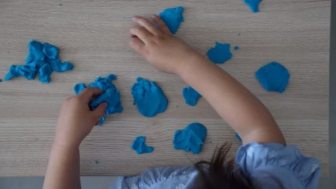 Child is playing with modeling clay and has a lot of fun. Video stock 124415989