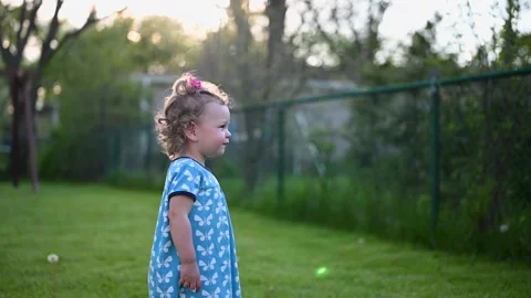 Child playing outside in bright sunlight Stock Footage 130522728