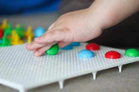 Child playing with pegboard mushroom nail mosaic Stock Photos