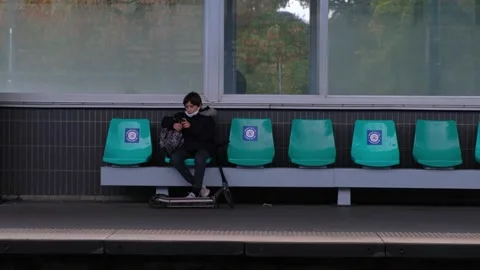 A child playing on the phone while waiting for the train Stock Footage 141089357