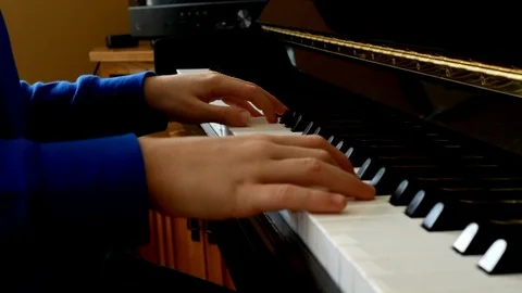 Child playing piano. Close up side view of young hands and fingers playing. Vidéo 103435151
