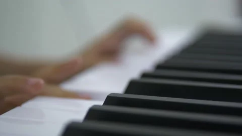 Child playing piano. Side view of a child playing piano Stock-Footage 167169628