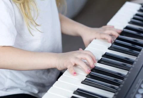 Child playing piano. Side view of a child playing piano. Close up on piano keys Stock Illustration
