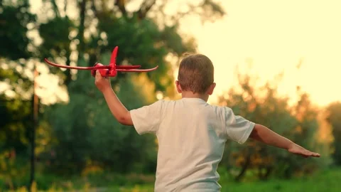 Child is playing pilot in open air. Little boy with an airplane runs park. Child Stock Footage 307449818
