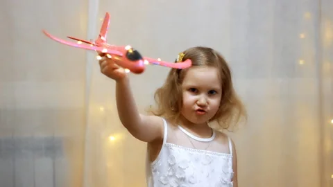 Child playing with the plane. Flight and travel concept. Baby girl pilot. Stock Footage 104588068