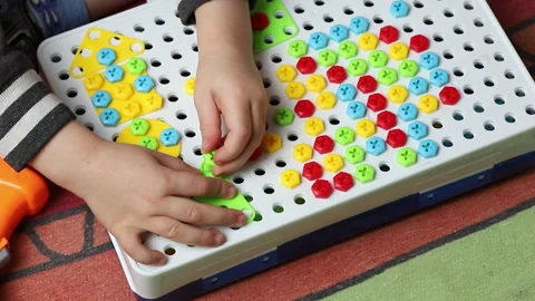 The child is playing with plastic screws and a screwdriver. Close-up Stock Footage 220139632