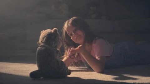Child playing with plush toy lying on the floor Stock Footage 243817014