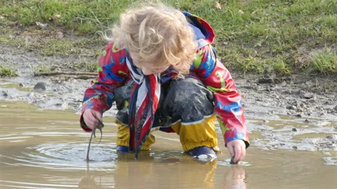Child playing in a puddle. Dirty. Stock Footage 149984029