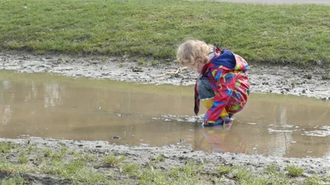 Child playing in a puddle. Stock Footage 149989865