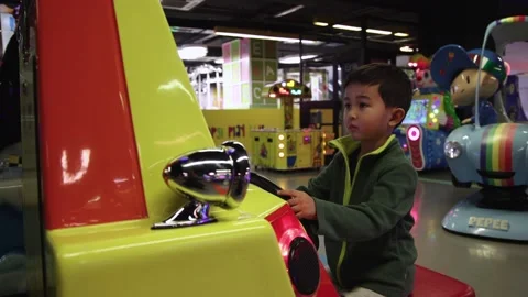 Child playing races on a slot machine with steering wheel Stock Footage 168970943