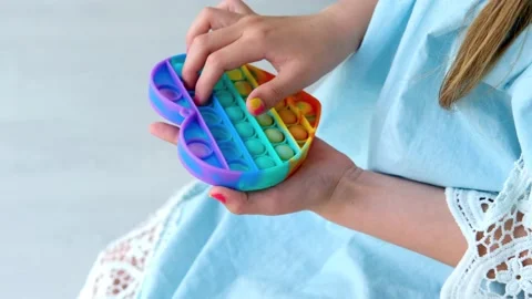 Child playing with rainbow pop it fidget toy. Stock Footage 154981486