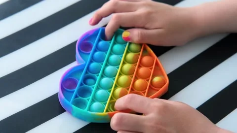 Child playing with rainbow pop it fidget toy. Stock Footage 154982167