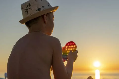 Child playing with a rainbow pop it, presses bubbles. anti-stress toy 库存照片