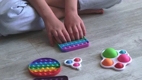 Child playing with rainbow popit. Modern silicone toys popit and simple dimple Stock Footage 158903059