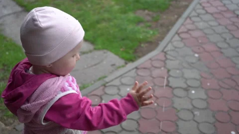 Child playing with raindrops Video stock 301530498