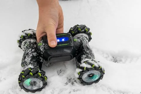 Child playing with remote control car in snow Foto stock