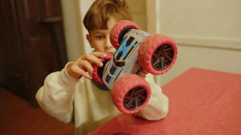 Child playing with a remote-controlled car he received as a present, in France Stock Footage 286710767