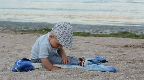 Child playing with sand and finding a shell on the beach Stock Footage 12274637