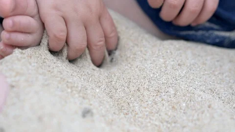 Child playing with the sand on the beach - close up slow motion shot Stock Footage 95936986